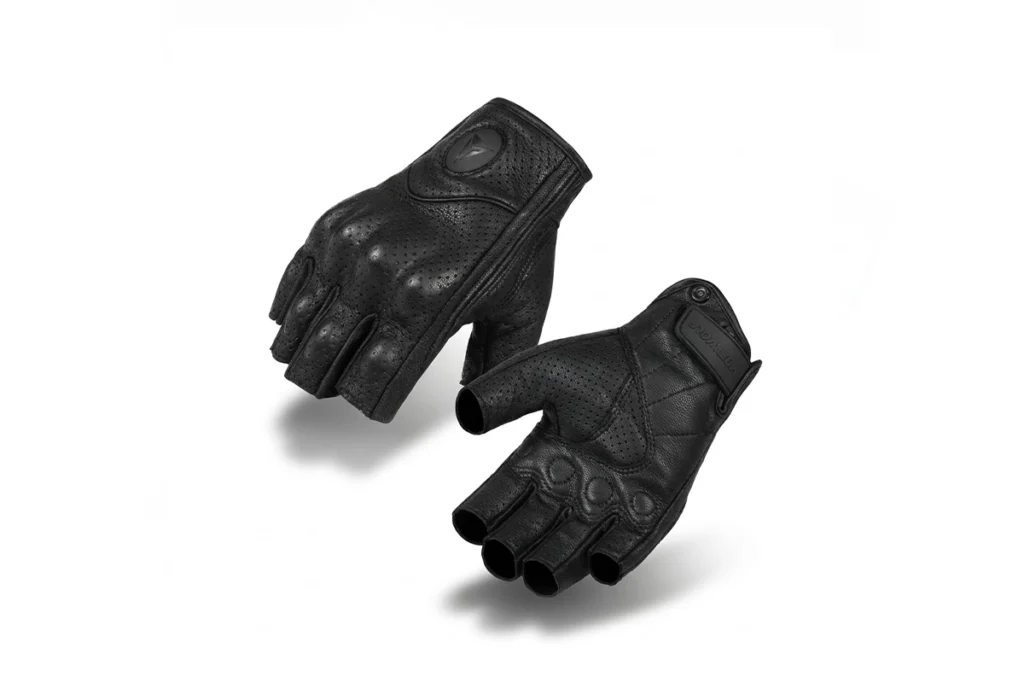 Pair of black Motowolf Genuine Leather Half Finger Gloves resting on a classic motorcycle gas tank